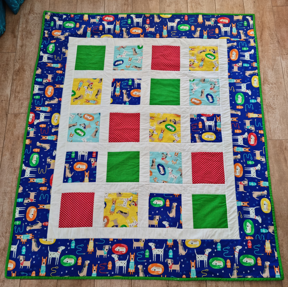 A baby quilt made with dog fabrics